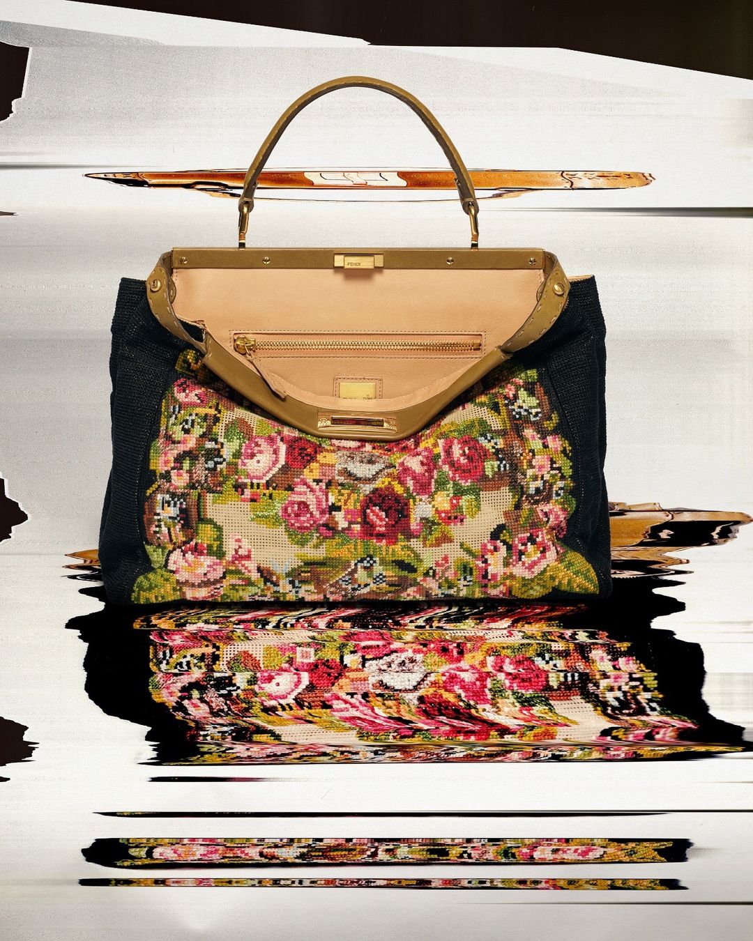 Floral-patterned Fendi Peekaboo handbag with brown leather handles, black textile sides, and light tan interior, on blurred background.
