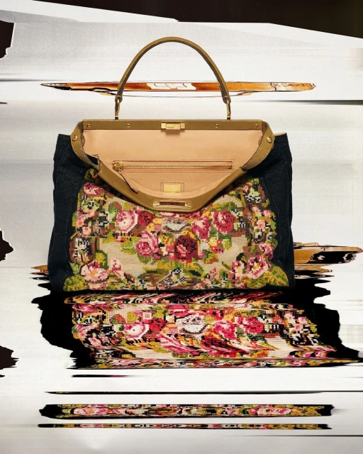 Floral-patterned Fendi Peekaboo handbag with brown leather handles, black textile sides, and light tan interior, on blurred background.