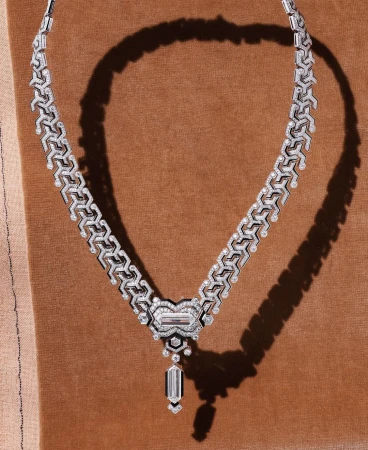 Elegant silver and diamond necklace displayed on a brown velvet surface with subtle lighting, showcasing a luxurious jewelry design.