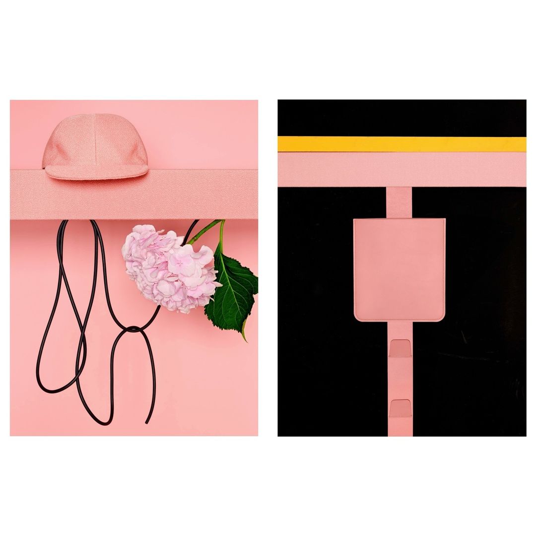 Still life featuring a pink baseball cap, a pink hydrangea, and a black cord against a pink background alongside a pink design.