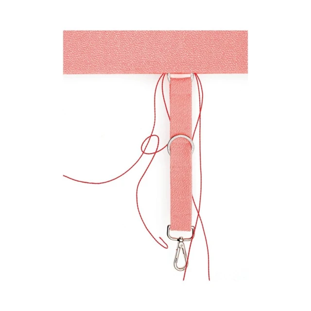 Close-up of a textured pink strap with metal rings, a clip, and loose red threads against a clean white background, studio shot.