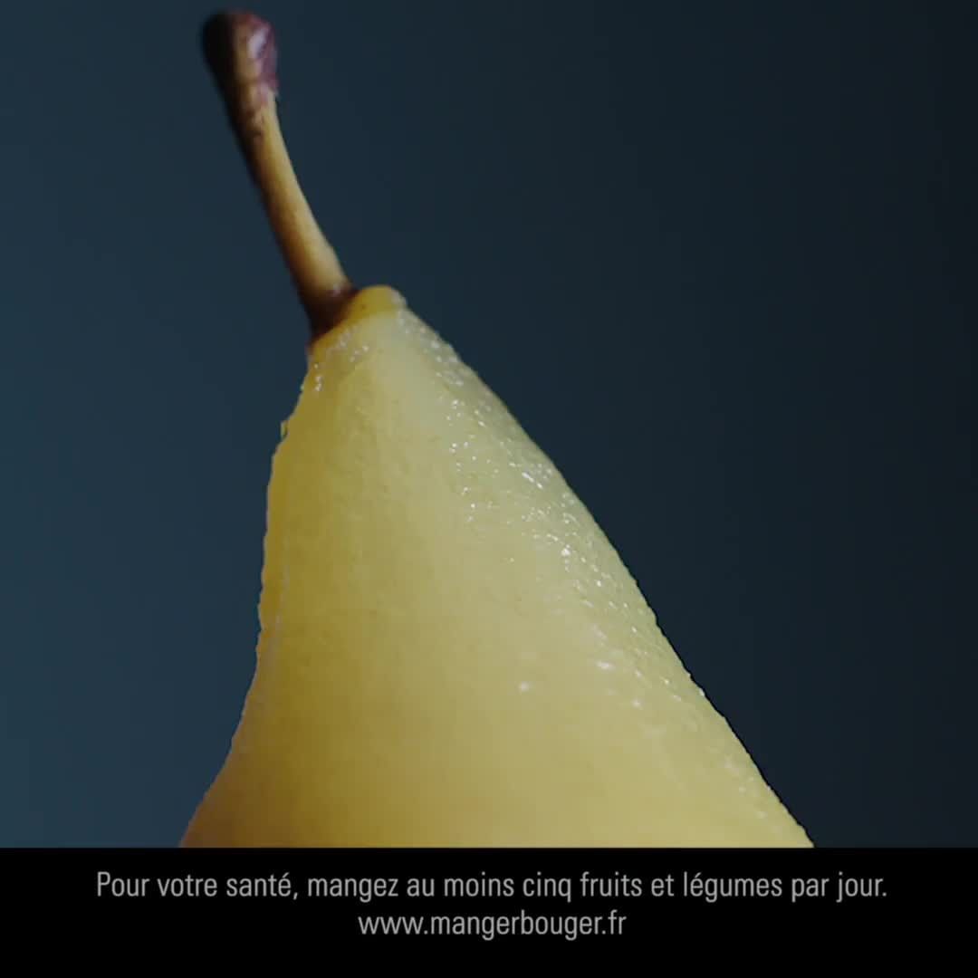Close-up studio shot of a ripe pear slice with a brown stem against a dark background. A message promoting healthy eating is visible.