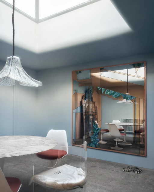 Interior with a round table and clear chairs, a decorative mirror reflecting another table and chairs, and a skylight overhead.