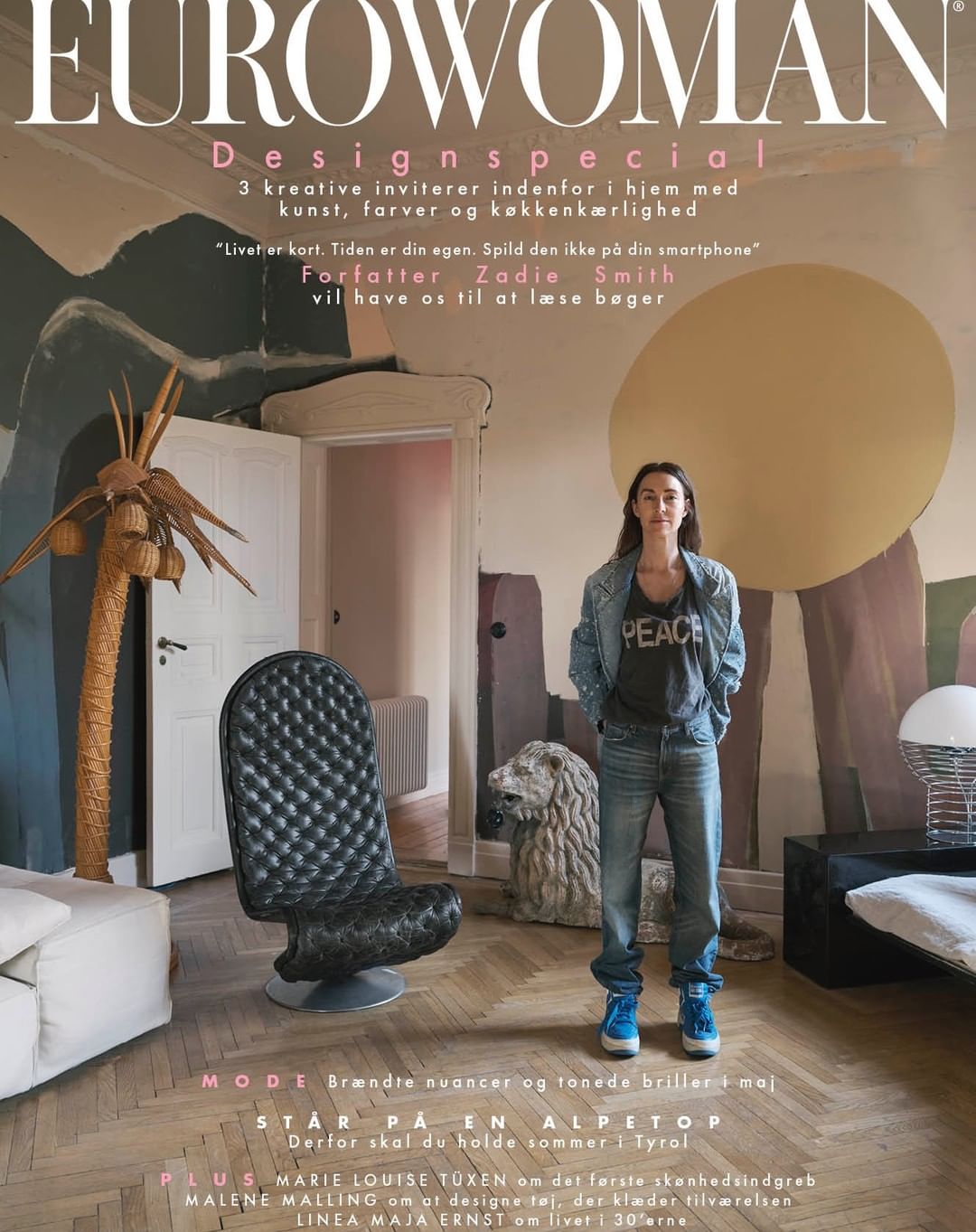 Magazine cover featuring a woman in a casual outfit standing indoors with a chair, sculpture, and text overlay.