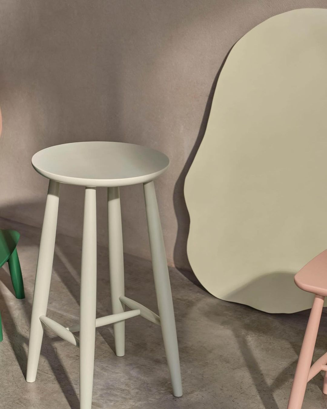 Three-legged stool in pastel light-blue color, modern minimalist design for home decor and furniture, against a neutral-toned background.