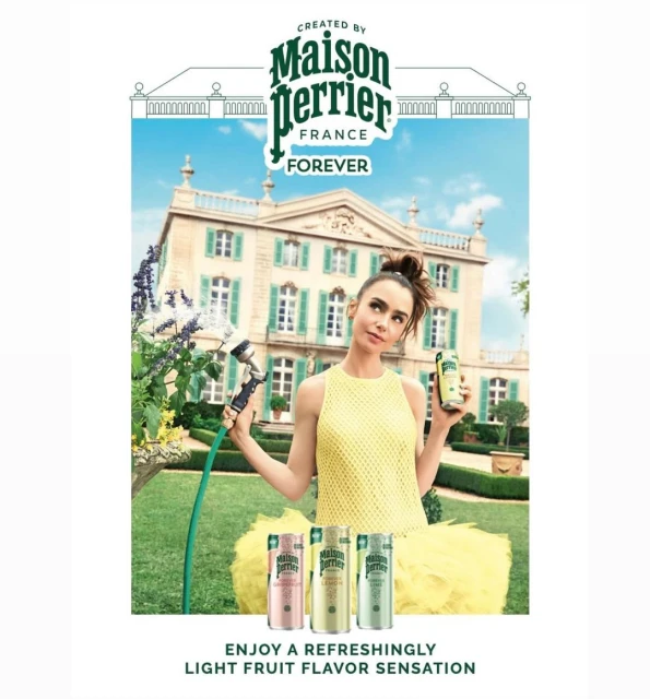 Lily Collins holds a Maison Perrier can in front of a mansion. She stands by a garden hose with Perrier cans at bottom.