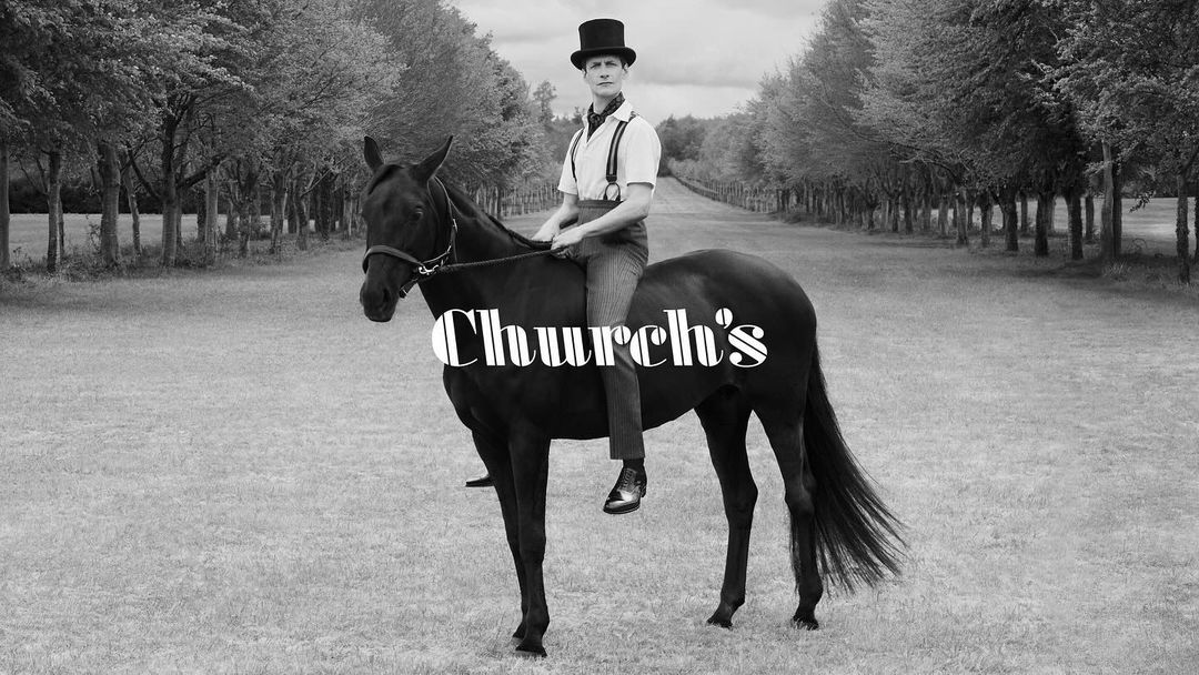 A black-and-white scene showcases a man in a top hat riding a black horse, with a tree-lined path stretching into the distance.