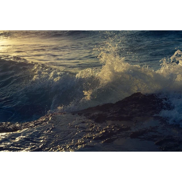 Ocean waves crashing against rocks during daytime, capturing the dynamic energy of the sea in a scenic seascape.