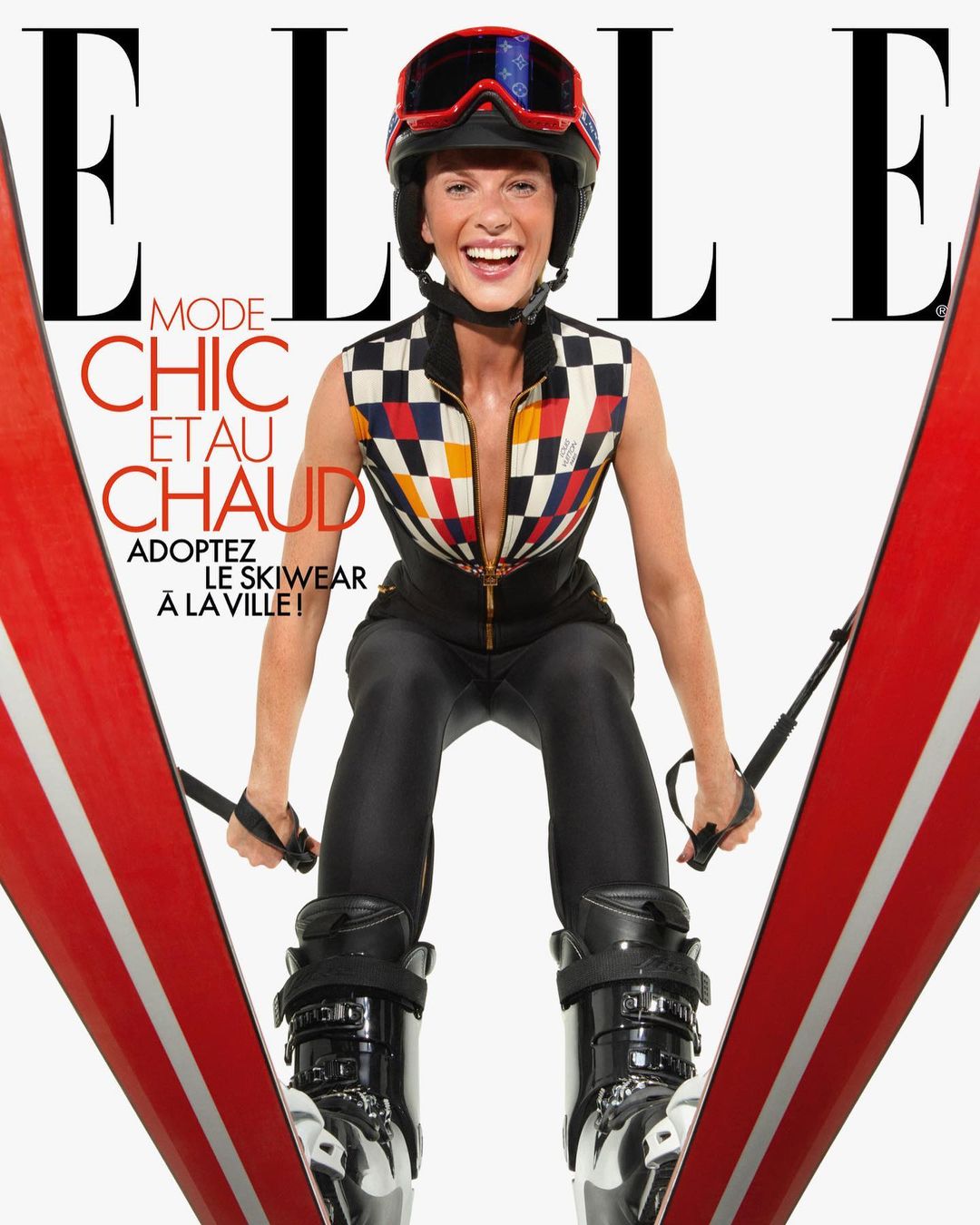 Elle magazine cover featuring a woman in ski gear, including a helmet and ski boots, holding skis, with the Elle logo and text.