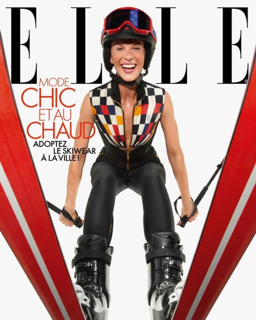 Elle magazine cover featuring a woman in ski gear, including a helmet and ski boots, holding skis, with the Elle logo and text.