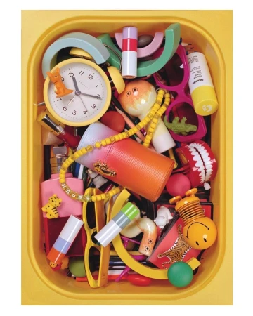 Overhead shot in a yellow container shows a collection of toys, eyewear, beauty products, beads, and household objects and novelties.