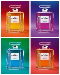 Four vibrant colored perfume bottles with diamond chains against multicolored studio backdrops.