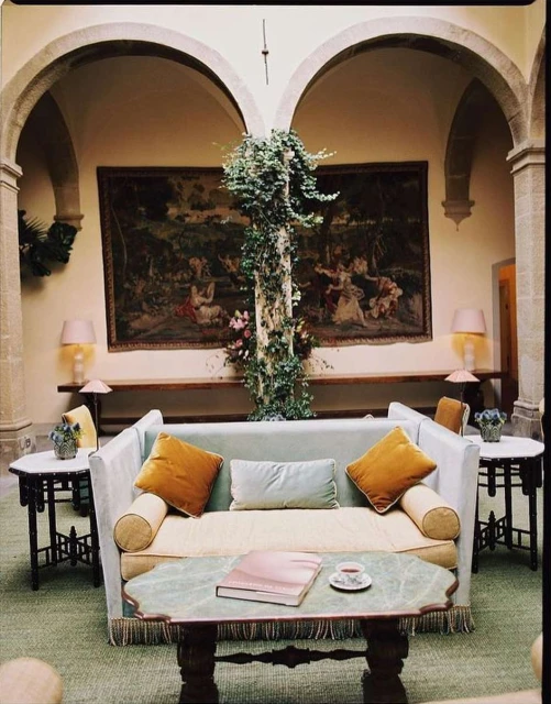Ornate interior with a plush sofa, decorative objects, and arched architectural details, creating a refined and inviting atmosphere.