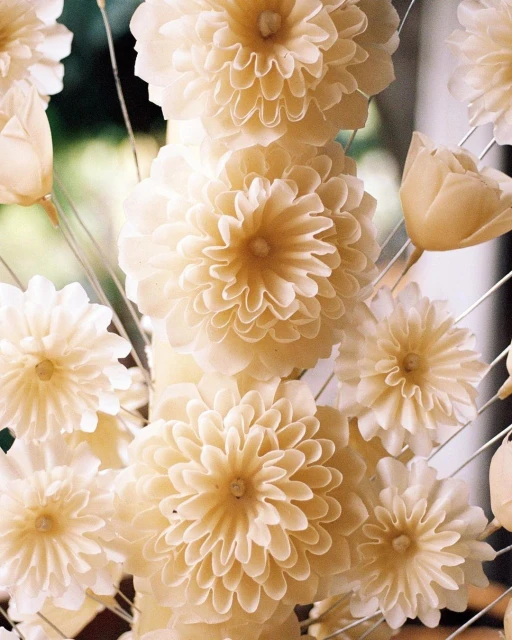 Floral arrangement featuring a bouquet of pale yellow flowers with a soft focus and shallow depth of field, creating a delicate and elegant composition.