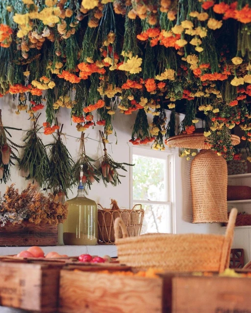Eye-level shot of an indoor space adorned with suspended dried flowers, rustic baskets, and wooden crates filled with more dried flowers.