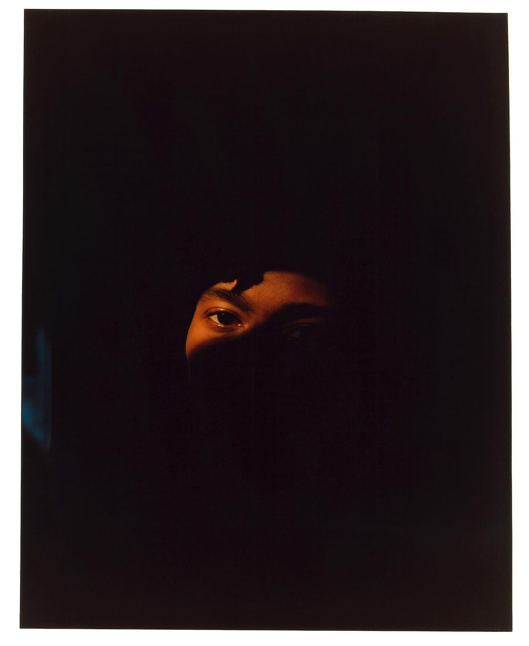 Close-up portrait of a person's eyes and forehead illuminated in deep shadow by director Pia Riverola.