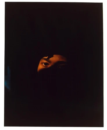 Close-up portrait of a person's eyes and forehead illuminated in deep shadow by director Pia Riverola.