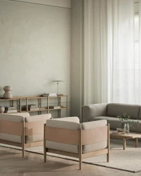 Minimalist living room interior featuring two upholstered armchairs, a matching sofa, and a low wooden coffee table.