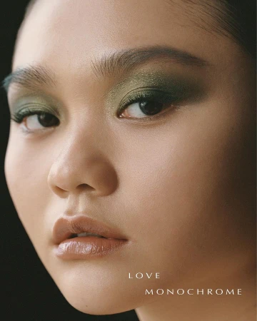 Close-up beauty portrait of a woman with green eyeshadow and glossy nude lips photographed by Piczo.