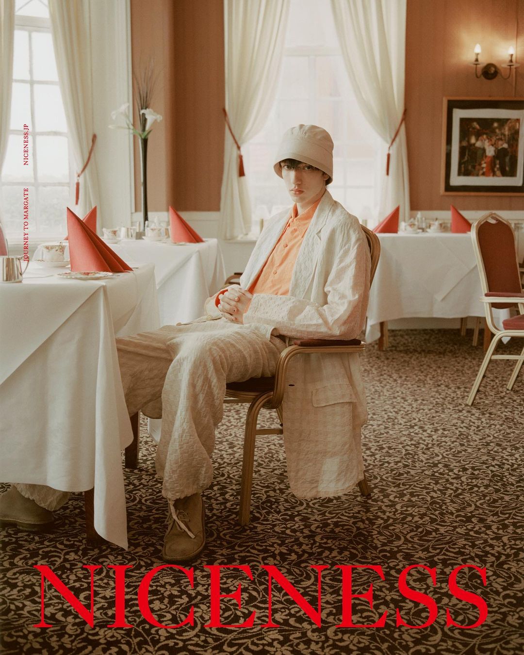 Stylish person sitting at table in restaurant. The image features an interesting color palette with orange and beige hues throughout.
