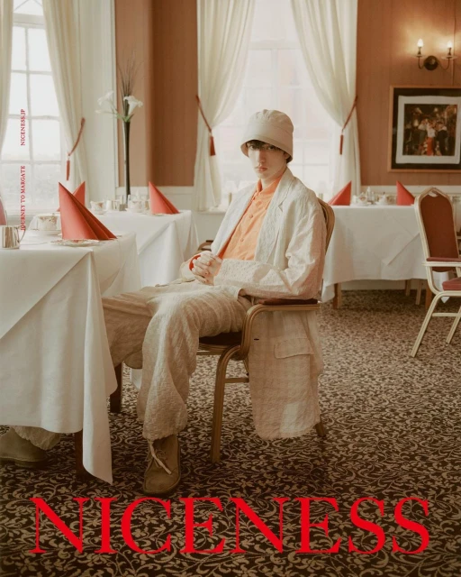 Stylish person sitting at table in restaurant. The image features an interesting color palette with orange and beige hues throughout.