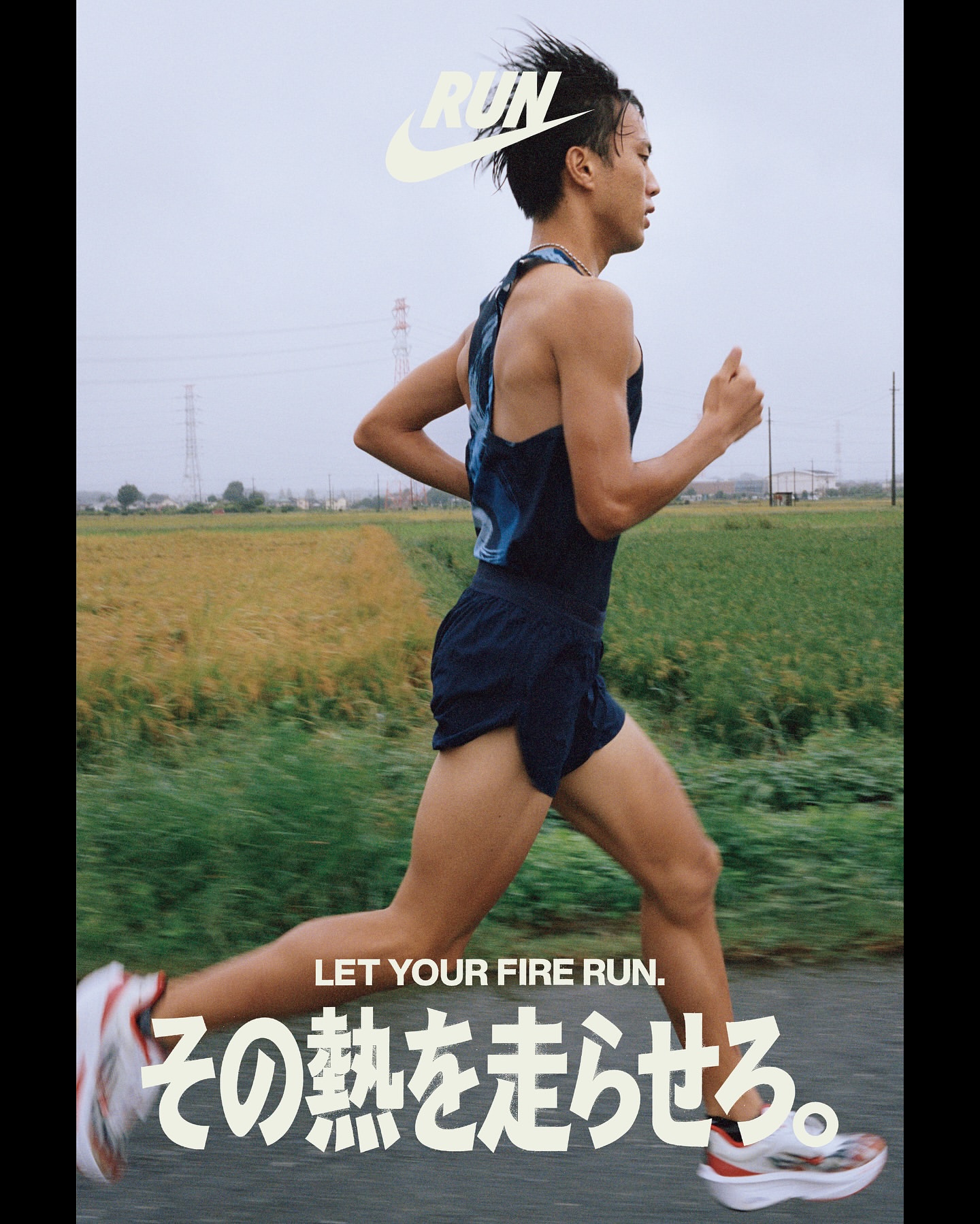Athlete running on rural road, wearing tank top and shorts, blurred motion, natural light, and sportswear brand logo.
