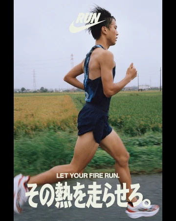 Athlete running on rural road, wearing tank top and shorts, blurred motion, natural light, and sportswear brand logo.