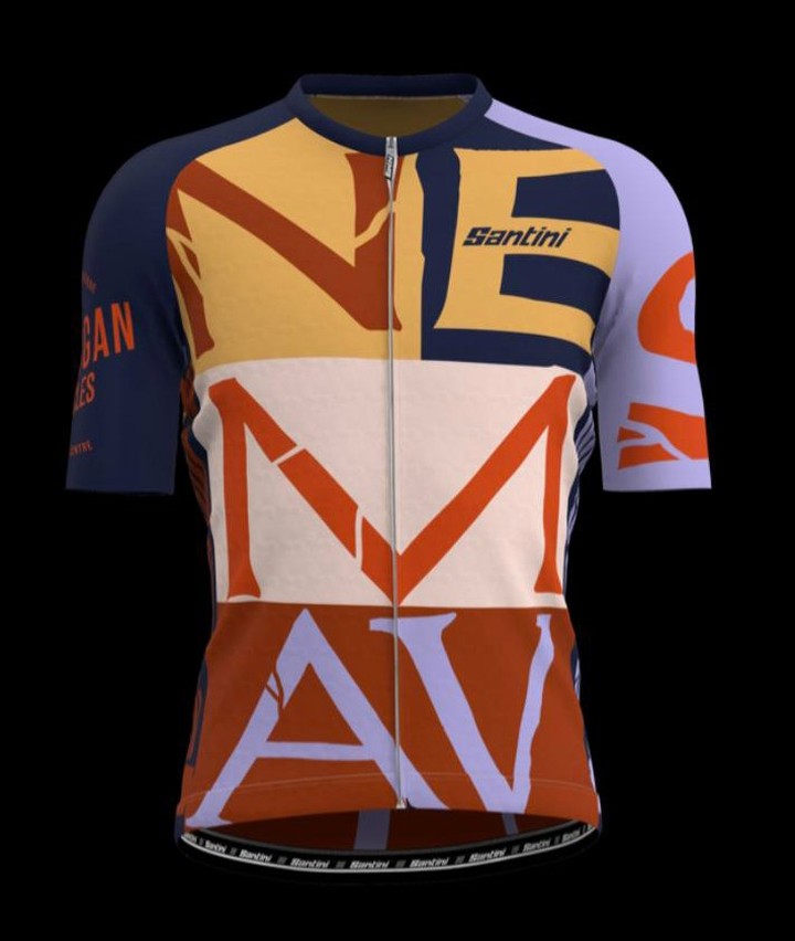 Colorful cycling jersey with bold block lettering and a quarter zipper, set against a stark black backdrop in a studio setting.