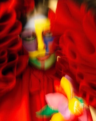 Colorful abstract portrait with flower-like shapes and a vivid color palette dominated by reds, yellows, greens, and blues.