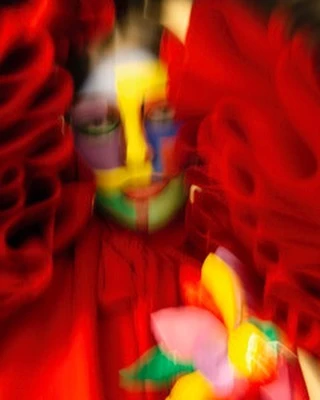 Colorful abstract portrait with flower-like shapes and a vivid color palette dominated by reds, yellows, greens, and blues.