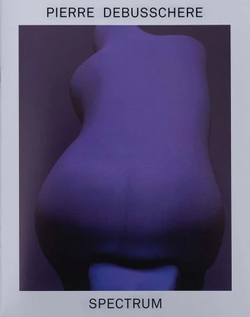 Back view of a female torso sculpture in a purple light against a purple background. Title text 'Spectrum' and artist name.