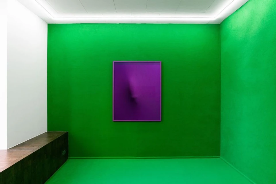 Minimalist interior scene with a purple abstract painting on a vibrant green wall in a room with a white ceiling and bench.