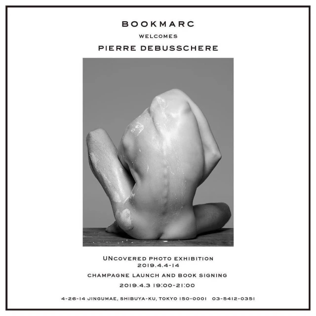 Black-and-white artistic nude portrait featuring a flexed adult male on a wooden surface, presented in a promotional poster for a photo exhibition.