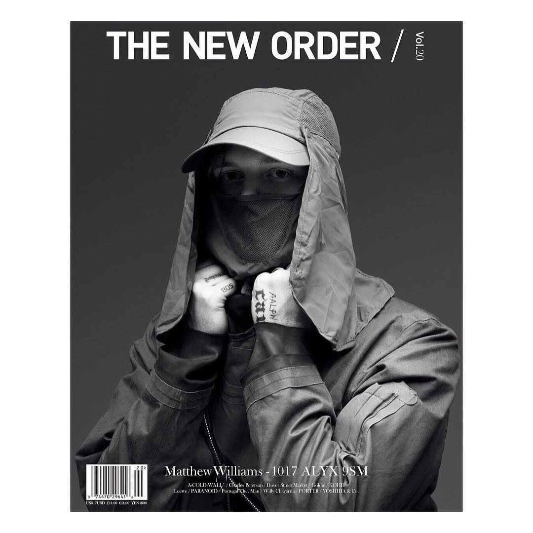 Monochrome portrait of adult male on a magazine cover wearing a cap and face covering, with overlaid typography and text elements.
