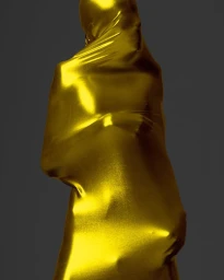 Figure completely enveloped in a metallic gold fabric against a dark grey background