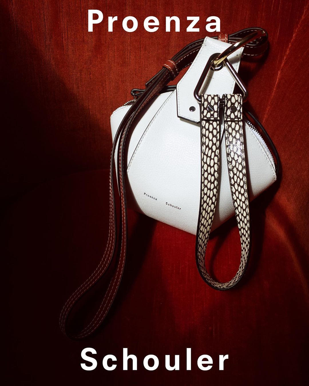 Proenza Schouler white leather handbag with patterned strap on a red background, studio lighting. Fashion accessory.