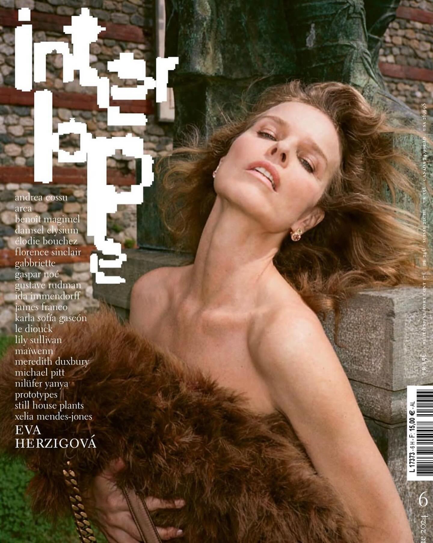 Magazine cover featuring a woman with curly hair, draped in a brown fur stole, posing against a stone background outdoors.