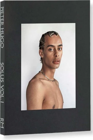 Book cover featuring a portrait of a bare-chested person with stylized hair and a silver chain against a stark white background.