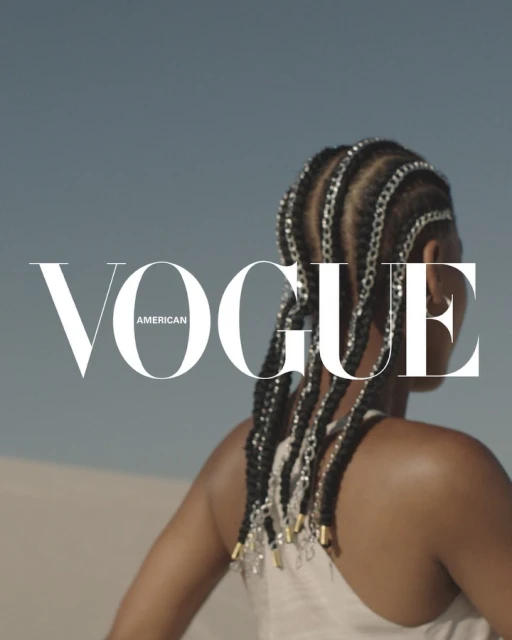 Fashion magazine cover featuring an adult woman with braids, wearing a neutral top, against a clear sky and sandy background.