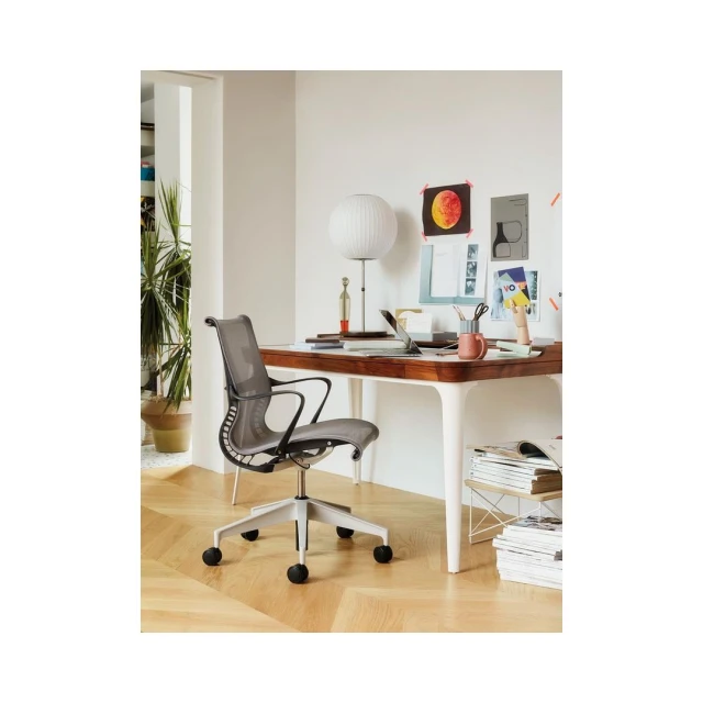 Ergonomic office chair situated in a bright, modern workspace with a wooden desk and white accents, creating a comfortable and stylish home office setup.