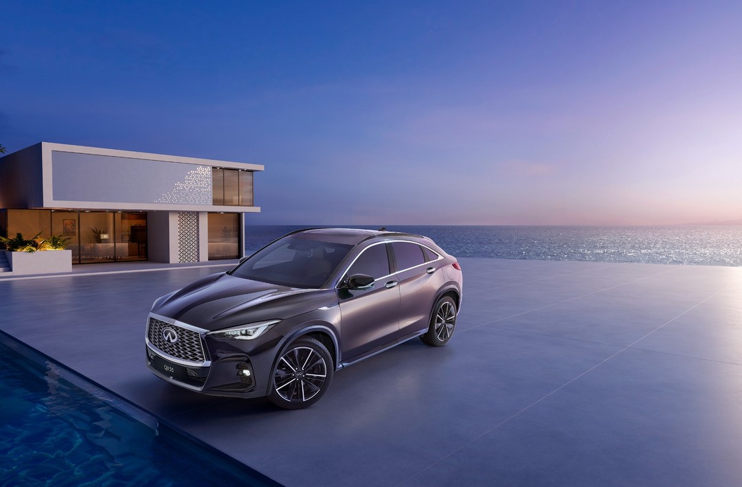 Sleek grey Infiniti QX55 SUV parked on a modern patio with ocean and sunset views, blending luxury automotive and scenic beauty.