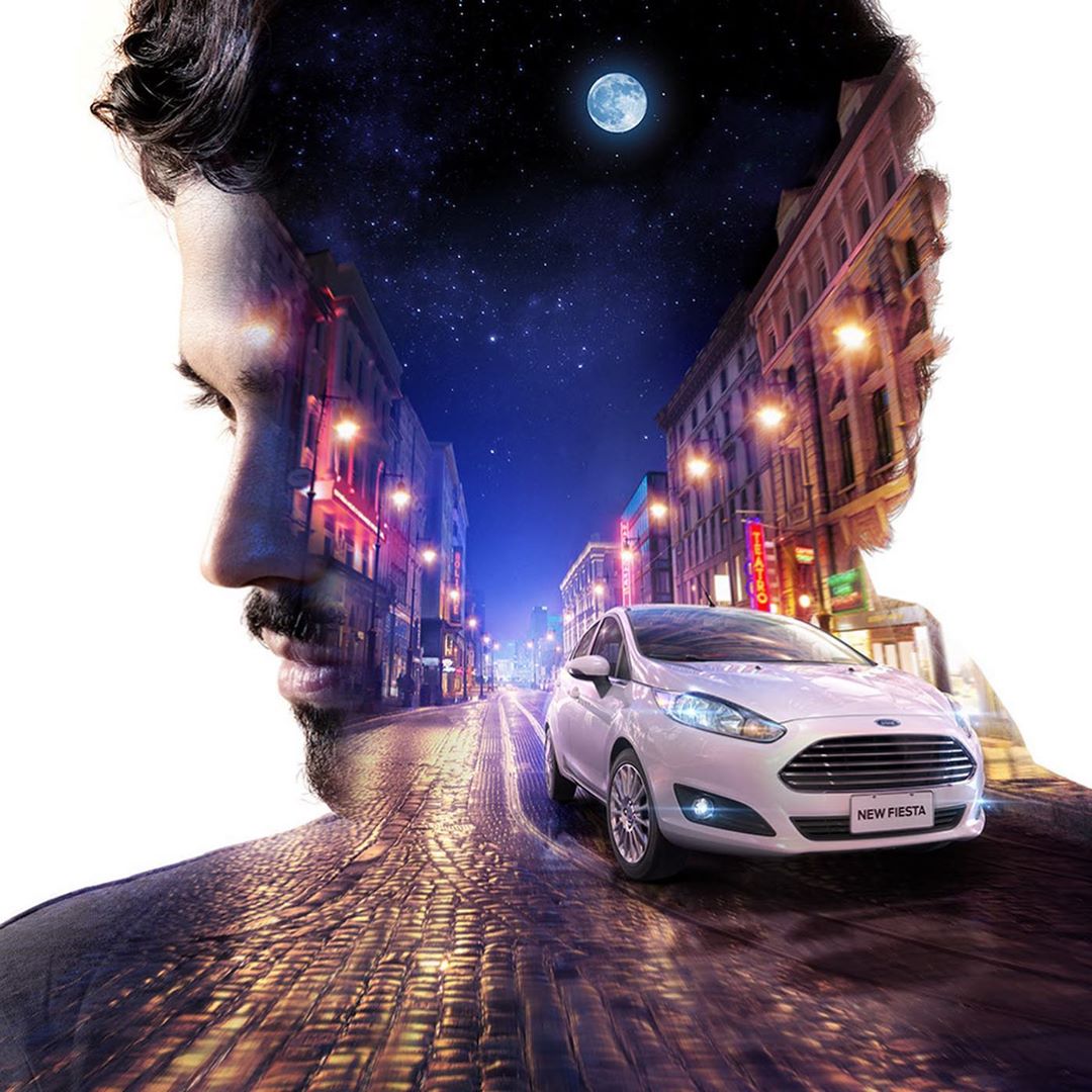 Double exposure image of a man's profile and a city street at night with a Ford Fiesta, blending urban and personal themes.