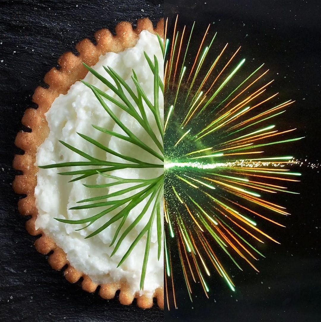 Abstract food art composition: cracker with cream cheese and chives, juxtaposed with fireworks, creates a visual contrast between nature and artifice.
