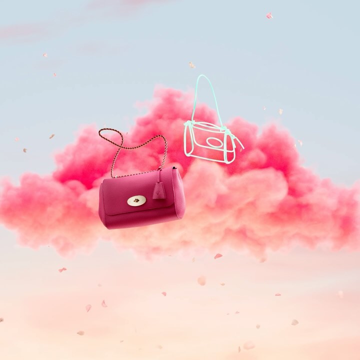 Pink purse and sketched handbag floating in a dreamy scene against pink clouds, with falling petals creating a surreal fashion moment.