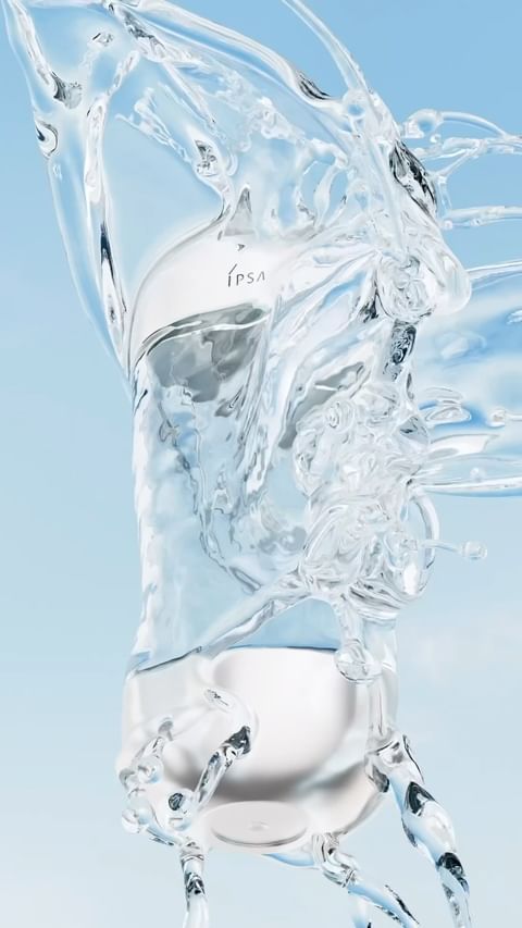 Product shot of a clear glass IPSA bottle filled with water and surrounded by splashing water against a light blue background.