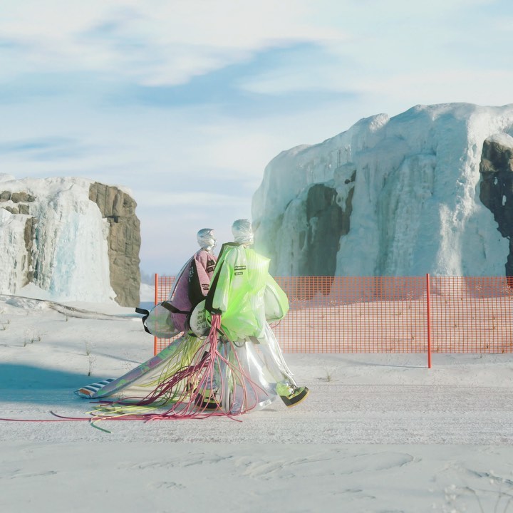 Two mannequins wear futuristic neon and iridescent outfits in a snowy arctic landscape, set against a backdrop of ice formations.