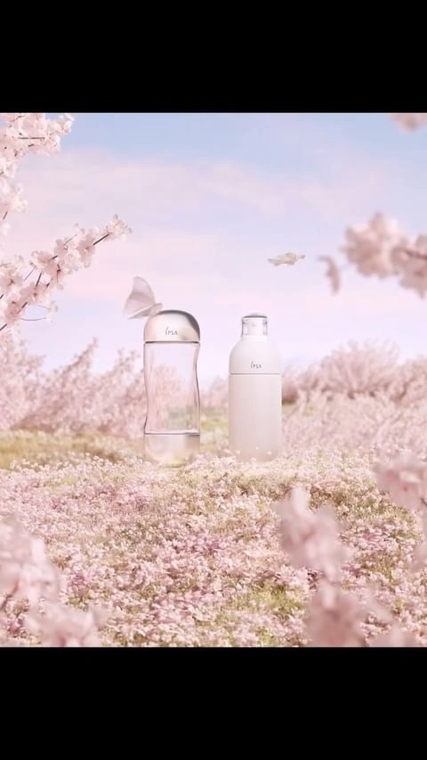 Two product bottles standing in a field of pink cherry blossoms under a soft pastel sky by Pleid Studio