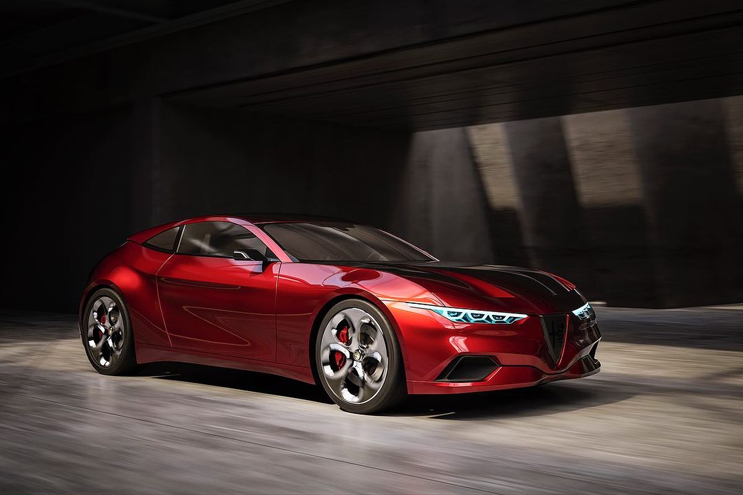 Red concept car with aerodynamic design parked in a dimly lit industrial setting, showcasing modern automotive form and style.