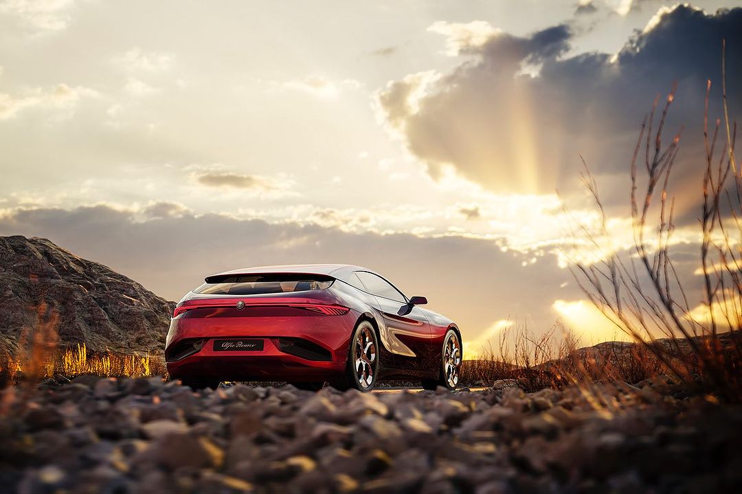 Alfa Romeo sports car on a rocky road with a sunset backdrop. The car is red, and the sky has golden light and dramatic clouds.