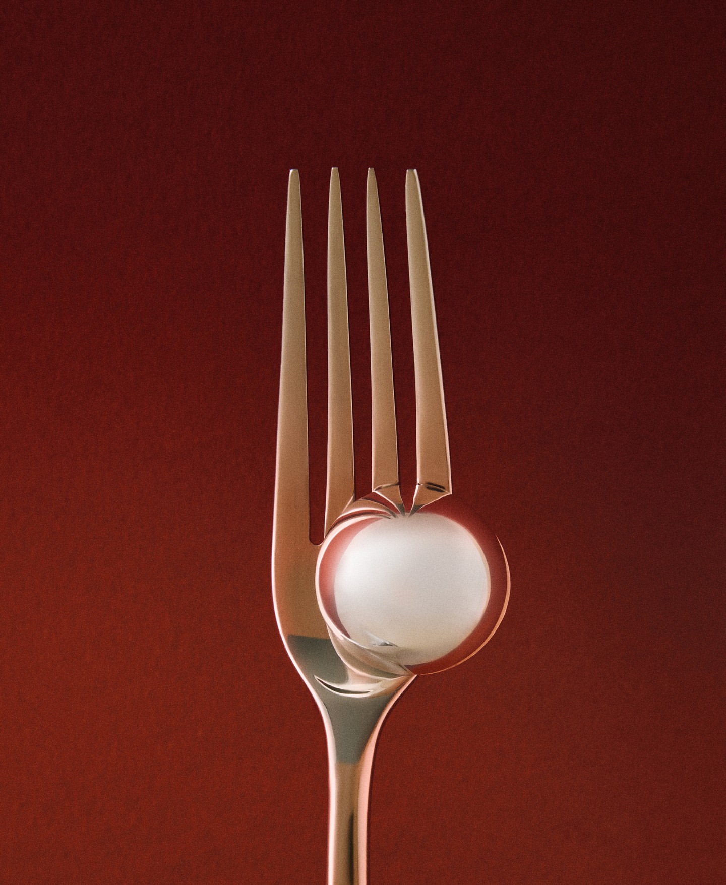 A close-up of a fork holding a white spherical object against a red background, creating a minimalist food or kitchenware image.